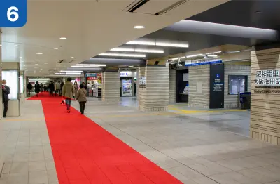 阪神電車大阪梅田駅を右手側に直進します。