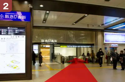 正面に阪急ターミナルビルの下りエスカレーター、階段で1階に降ります。